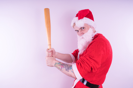 Emotional Santa Claus with a tattoo of a bat on a white background. The concept of an evil Santa Claus. Happy New Year and merry Christmas!の写真素材