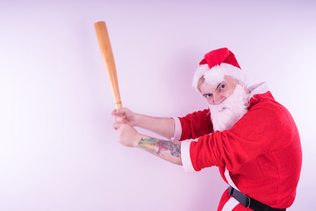 Emotional Santa Claus with a tattoo of a bat on a white background. The concept of an evil Santa Claus. Happy New Year and merry Christmas!の写真素材