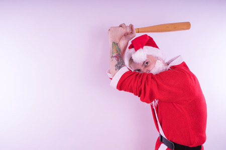 Emotional Santa Claus with a tattoo of a bat on a white background. The concept of an evil Santa Claus. Happy New Year and merry Christmas!の写真素材