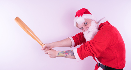 Emotional Santa Claus with a tattoo of a bat on a white background. The concept of an evil Santa Claus. Happy New Year and merry Christmas!の写真素材
