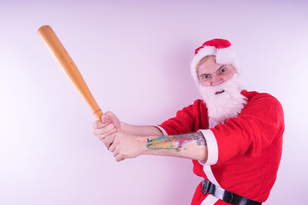 Emotional Santa Claus with a tattoo of a bat on a white background. The concept of an evil Santa Claus. Happy New Year and merry Christmas!の写真素材