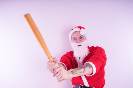 Emotional Santa Claus with a tattoo of a bat on a white background. The concept of an evil Santa Claus. Happy New Year and merry Christmas!の写真素材