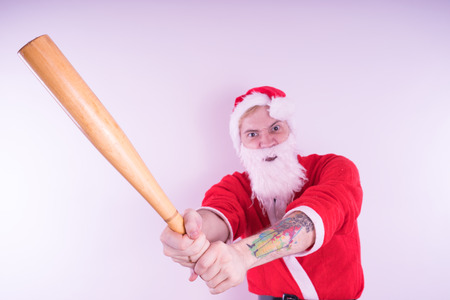 Emotional Santa Claus with a tattoo of a bat on a white background. The concept of an evil Santa Claus. Happy New Year and merry Christmas!の写真素材
