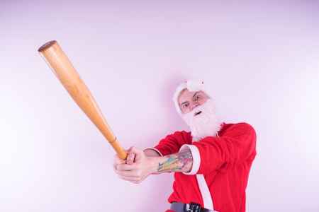 Emotional Santa Claus with a tattoo of a bat on a white background. The concept of an evil Santa Claus. Happy New Year and merry Christmas!の写真素材