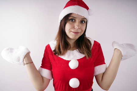 Portrait of a young girl dressed as Santa Claus on a white background. Happy New Year and merry Christmas!の写真素材