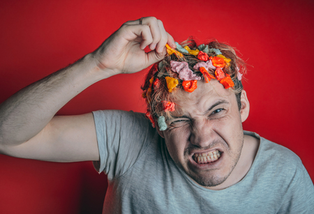 Gum in his head. Portrait of a man with chewing gum in his head. Man with hair covered in food. Hen red hairの写真素材