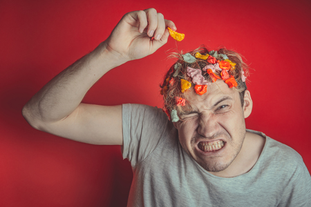Gum in his head. Portrait of a man with chewing gum in his head. Man with hair covered in food. Hen red hairの写真素材