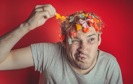 Gum in his head. Portrait of a man with chewing gum in his head. Man with hair covered in food. Hen red hairの写真素材
