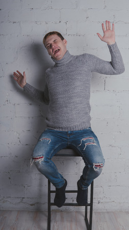 On a gray background. A man posing against a brick wall.の写真素材