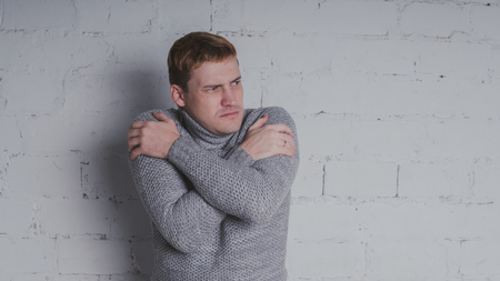 On a gray background. A man posing against a brick wall.の写真素材
