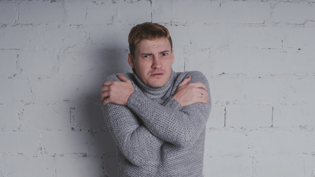 On a gray background. A man posing against a brick wall.の写真素材