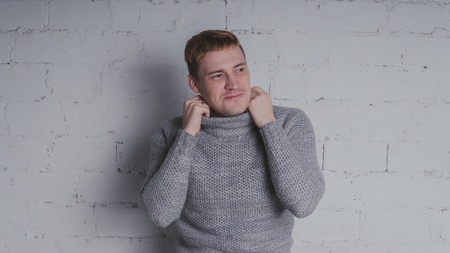 On a gray background. A man posing against a brick wall.の写真素材