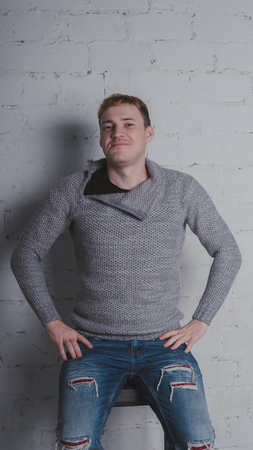On a gray background. A man posing against a brick wall.の写真素材