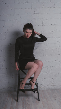 Young pretty woman or fashionable sexy girl with cute face, copy space. White brick wall background.の写真素材