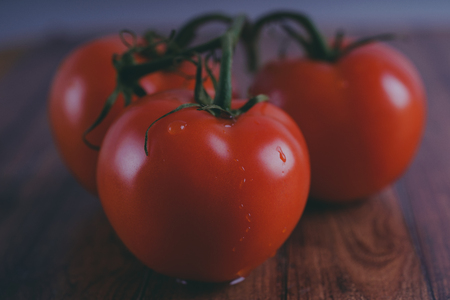 Red, juicy tomatoes on wooden background, concept: fresh vegetables, healthy food.の写真素材