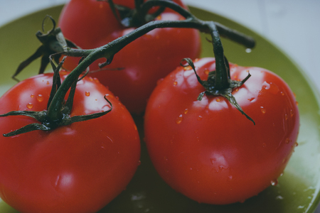 Red, juicy tomatoes on wooden background, concept: fresh vegetables, healthy food.の写真素材
