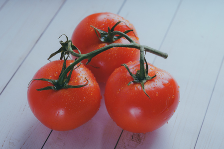 Red, juicy tomatoes on wooden background, concept: fresh vegetables, healthy food.の写真素材