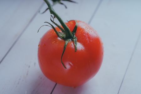 Red tomato on wooden background, concept: fresh vegetables, healthy food.の写真素材