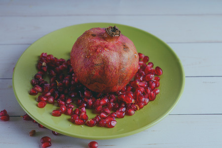 Red pomegranate wooden background, concept: fresh vegetables, healthy food.の写真素材