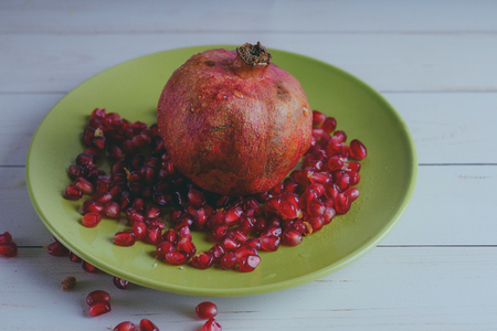 Red pomegranate wooden background, concept: fresh vegetables, healthy food.の写真素材