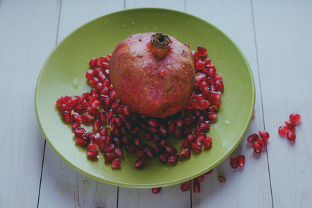 Red pomegranate wooden background, concept: fresh vegetables, healthy food.の写真素材