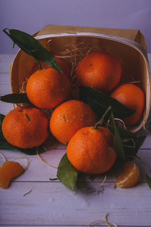 Fresh tangerines on a wooden background. Mandarins with copy space for text. Ripe and tasty tangerines. Clementines on a wooden table. Background tangerines.の写真素材