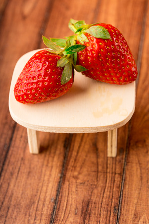 Fresh berries on the table. Red strawberries in a brown bowlの写真素材