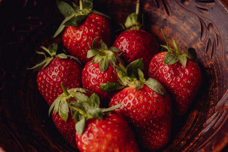 Fresh strawberries in a clay plate. Fresh berries on the table. Red strawberries in a brown bowl. Fruit close-upの写真素材