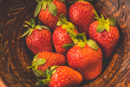 Fresh strawberries in a clay plate. Fresh berries on the table. Red strawberries in a brown bowl. Fruit close-upの写真素材