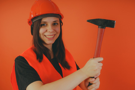 Girl Builder with hammer in hand, concept: girl doing repairs. An image of a road worker or surveyorの写真素材