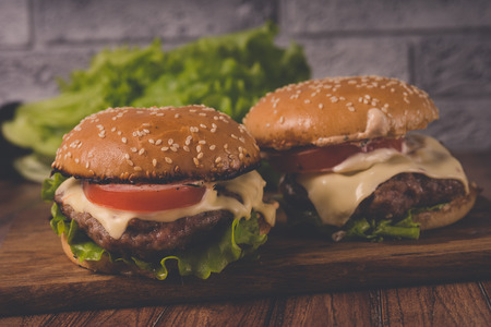 ?amburger or sandwich on brown paper. Delicious sandwich hamburger with meat, cheese and fresh vegetable. Hamburger or sandwich Juicy cheeseburgerの写真素材
