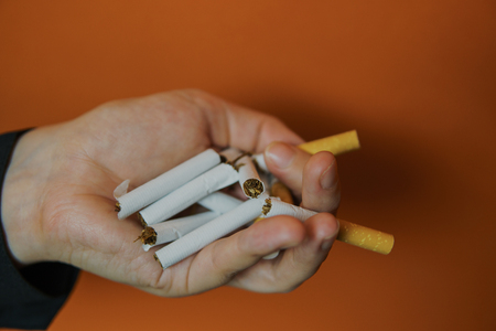 Crop woman holding split cigarette. Closeup of crop woman holding unlit split cigarette on palmの写真素材