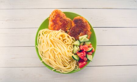 traditional dish consisting of spaghetti with chicken cutlets and vegetable salad.の写真素材