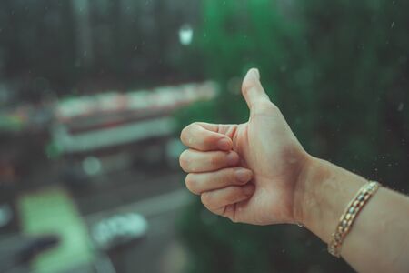 Rainy weather, rain drops falling on womans hand.の写真素材