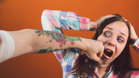 A frightened young woman got punched in the face.の写真素材