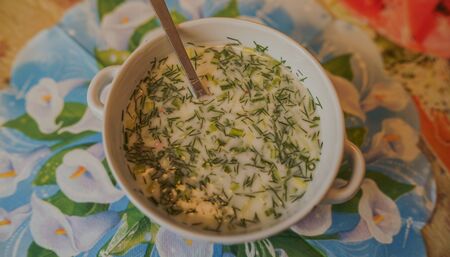 Cold soup name - okroshka, the national dish of the cuisine of Russia and Ukraine. Cold soup with fresh cucumbers, radishes, potato and sausage with yoghurt in bowl.の写真素材