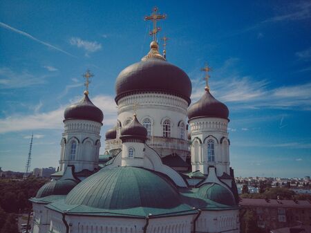 Golden domes with a crosses on the Christian Orthodox Church shine on a sunny day against blue sky.の写真素材