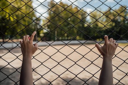 The hands on the lattice are symbolize limitation in something.の写真素材
