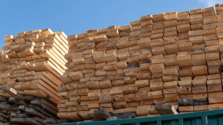 Wooden boards, lumber, industrial wood, timber. Pine wood timber stack of natural rough wooden boards on building site.の写真素材