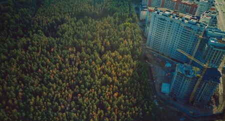 Constructing building with high crane under clear skyの写真素材