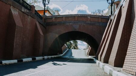 An old stone bridge over the roadway in the cityの写真素材