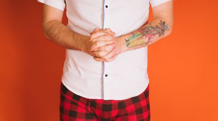 Male body in the plaid boxers and in white shirt on orange background.の写真素材