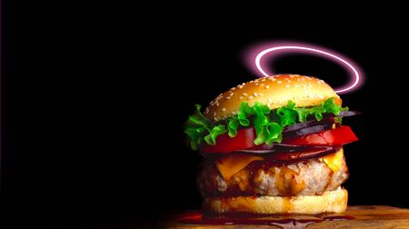 Burger with a halo on a black background. Hamburger with dripping sauce on a juicy cutlet.の写真素材