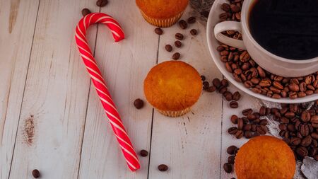 Close up still life, cup of coffee with muffins. Freshly baked delicious muffins and cup of coffee on wooden table.の写真素材