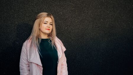 A portrait of a beautiful girl, posing against the background of a gray wallの写真素材