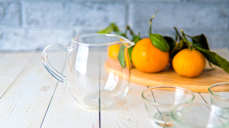 A glass teapot with the small cups on the tableの写真素材