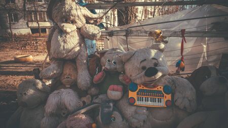Old and battered soft toys lie on the street.の写真素材