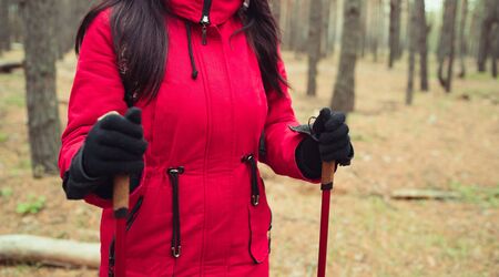 A young woman is engaged in the nordic walking in woodsの写真素材