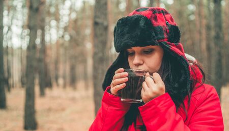 A portrait of the pretty woman with a cup of tea in woods.の写真素材