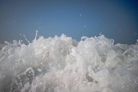 The low tide from the sandy beach. Ocean waves are splashing on the shoreの写真素材